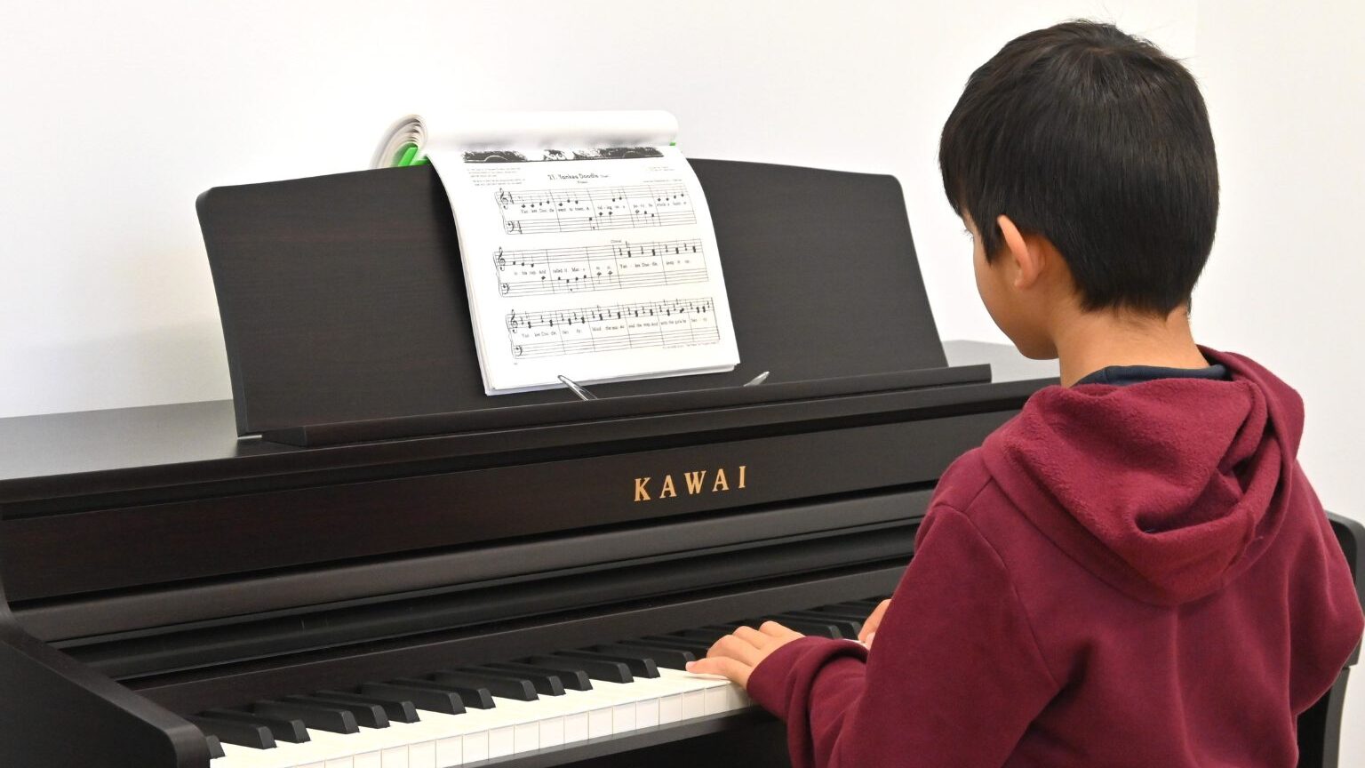 Un enfant joue du piano numérique.